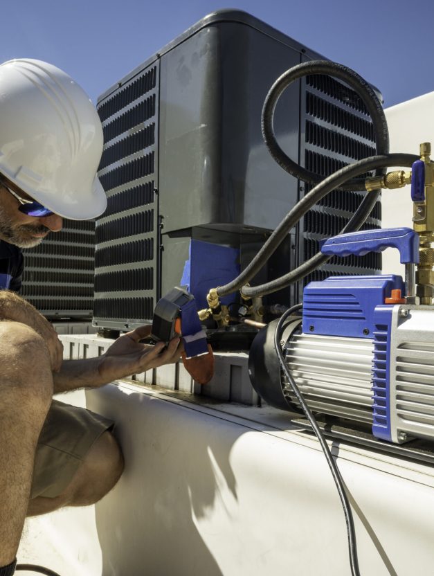 HVAC technician monitoring a vacuum gauge after an air conditioning repair