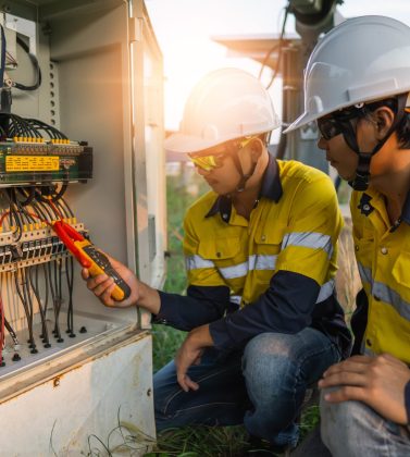 Workers use clamp meter to measure the current of electrical wires produced from solar energy for confirm to normal current.